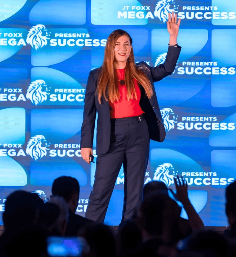 Atena Pegler speaking on stage at Mega Success conference
